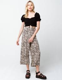 Sisstrevolution Dusty Skies WVN Pant in black floral print, styled with a black crop top.
