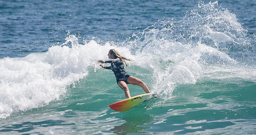 Surfer riding a wave in vibrant 7 Seas wetsuit, showcasing dynamic ocean action.